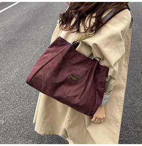 Detailed macro view of burgundy retro tote bag with metal chain and leather strap
