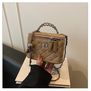 Macro view of khaki quilted suede box bag with chain strap and metal ball charm