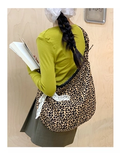 Detailed leopard print tote bag featuring a white lace bow accent on the shoulder strap