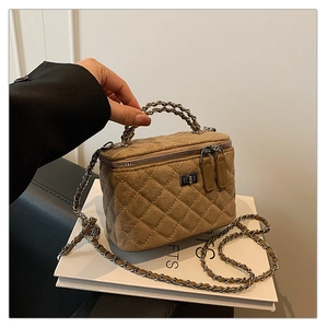 Detail view of khaki quilted crossbody box bag with silver hardware and chain strap