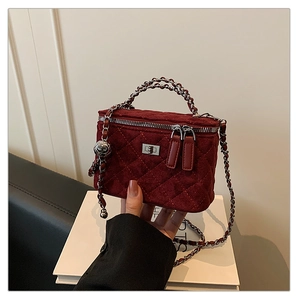 Detail of wine red quilted box bag with silver twist lock and chain strap for women