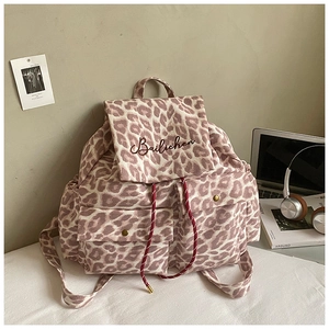 Detail of leopard print canvas backpack with woven drawstrings and front pockets