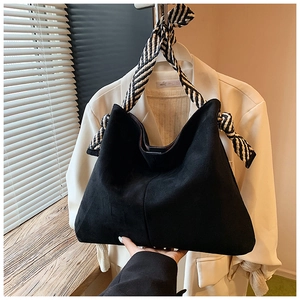 Detail of black faux suede tote bag featuring distinctive black and white woven rope handles