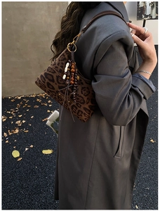 Détail du sac léopard avec pampille en perles vintage et plaque de logo dorée