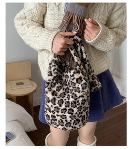 Detail of soft leopard print faux fur bucket bag shown in a cozy winter lifestyle setting