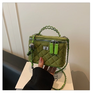 Detail of green quilted suede camera bag featuring silver square lock and chain handle
