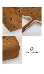 Detail showing puppy and bow embroidery on brown suede fabric with soft fleece lining