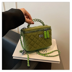 Close-up of grass green quilted box bag featuring silver chain strap and velvet texture