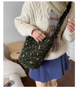 Détail d'un grand sac cabas en peluche léopard vert porté par un mannequin en hiver
