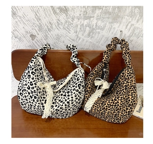 Detail view of leopard print shoulder bags with scrunchie handles and pearl charms