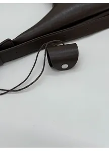 Détail de la texture cuir marron foncé avec une mini pochette décorative assortie
