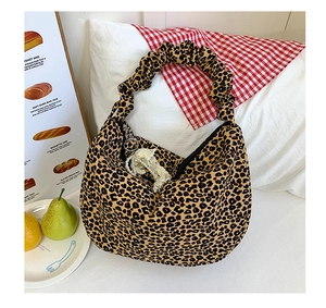 Leopard print hobo bag with scrunchie handle, pearl lace bow charm, and spacious fabric design