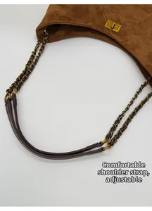 Details des verstellbaren Leder- und Goldkettenriemens der braunen Wildledertasche