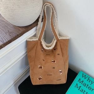 Detail of caramel corduroy tote bag featuring puppy embroidery and sherpa fleece lining