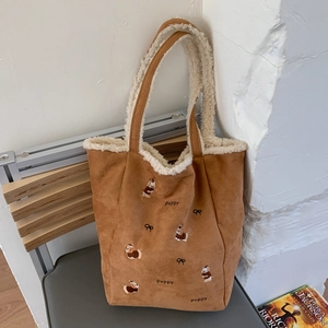 Close-up of brown corduroy tote with puppy embroidery and faux shearling trim details