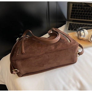 Detail of vintage dark brown suede tote bag with metal zippers and brass hardware