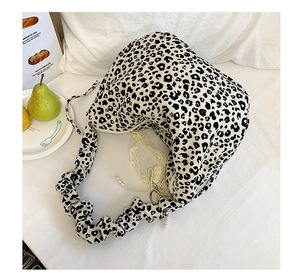Close-up of leopard print crossbody bag featuring lace ribbons and pearl charm details