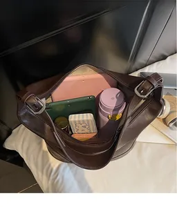 Detailaufnahme des geräumigen Hauptfachs und der Innentaschen der braunen Beuteltasche