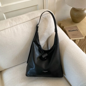 Dettaglio della borsa hobo in pelle nera di alta qualità con stampa logo su divano