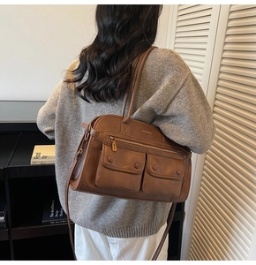 Detail shot of brown vintage leather bag with double front pockets and adjustable strap