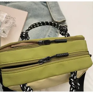 Close-up of contrast zipper detail and woven rope handle on the canvas crossbody bag