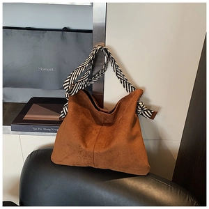 Detail of caramel suede tote bag with stylish zebra-print woven shoulder strap