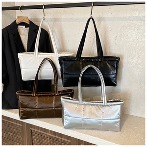 Detailed view of quilted puffer tote bags in four metallic colors with glossy finish