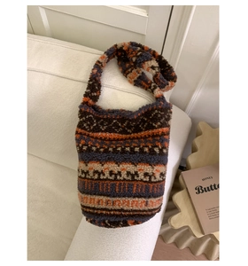 Gros plan détaillé des motifs jacquard rétro sur ce sac seau en peluche doux pour hiver