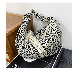 Detail of leopard print tote bag with ruffled strap and lace bow pearl charm decoration