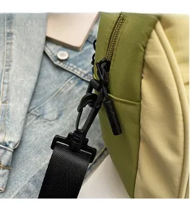 Detail of durable black swivel hook and detachable strap on green and yellow canvas bag