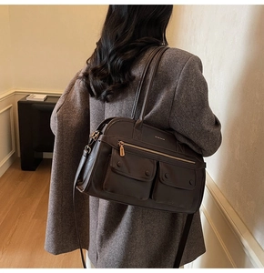 Detailed view of dark brown tote bag with matte texture and dual front snap-flap pockets