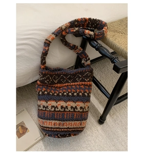 Detail of plush lamb wool bucket bag with retro ethnic patterns in a cozy home setting