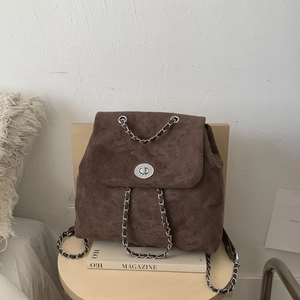 Détail d'un sac à dos en daim matelassé marron avec fermoir rotatif argenté