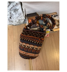 Detail of vintage bohemian jacquard sherpa crossbody bag on a stack of books