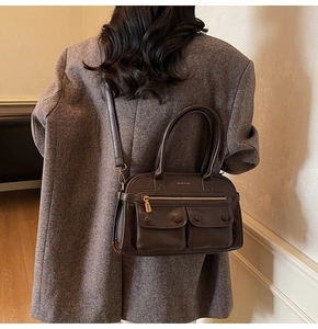 Lifestyle shot of a vintage brown crossbody tote bag featuring multiple front pockets