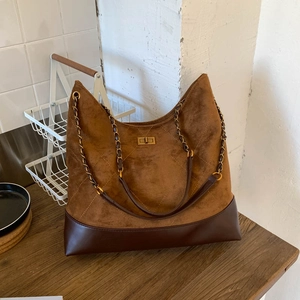 Detail der Retro-Einkaufstasche mit Wildleder-Nähten und goldenem Drehverschluss-Design
