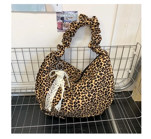 Close-up of leopard print hobo bag featuring pleated handle and pearl lace charm
