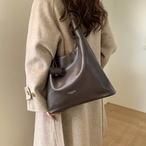 Dettaglio della borsa tote in pelle marrone scuro con scritta Muting and Bags