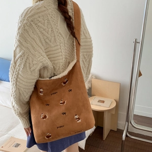 Detail of brown corduroy bucket bag with plush lamb wool lining and puppy embroidery