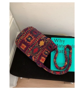 Detailed view of plush lamb wool bucket bag with ethnic geometric patterns on black surface