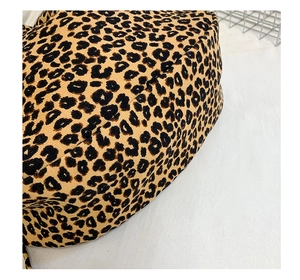 Close-up of leopard print canvas fabric texture and stitching on large hobo bag