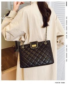 Détail d'un sac bandoulière en cuir matelassé noir avec chaîne dorée sur mannequin