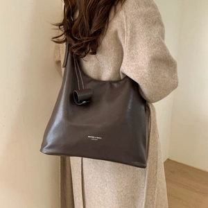 Dettaglio della grande borsa tote in pelle marrone scuro con scritta Muting and Bags