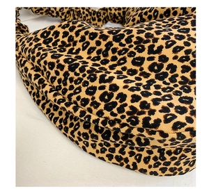 Close-up of leopard print fabric texture and pleated stitching details on a tote bag