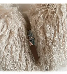 Detail of silver twist-lock hardware on white faux fur bucket bag with brown leather strap