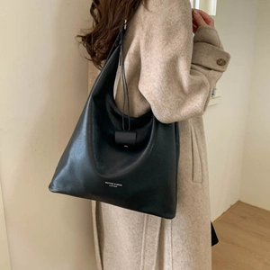 Dettaglio macro del logo bianco stampato sulla borsa hobo in pelle nera da donna