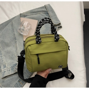 Detail of green nylon crossbody bag with polka dot handles and adjustable wide strap