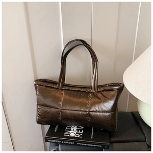 Macro shot of metallic brown quilted tote bag material with high-gloss puffer finish