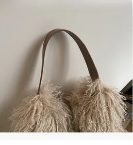 Detailed view of plush lamb wool bucket bag texture with durable brown leather handle