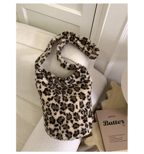 Détail du sac cabas à motif léopard en fausse fourrure douce posé sur un canapé blanc